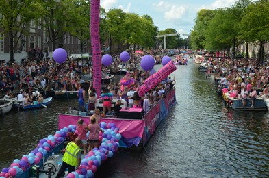 AMSTERDAM, NETHERLANDS - AUGUST 06, 2022: Many people in boats at LGBT pride parade on river