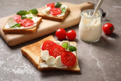 Tasty toast bread with cream cheese and cherry tomatoes on color background