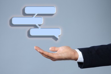 Image of Communication and dialogue concept. Businessman with illustration of speech bubbles on grey background, closeup
