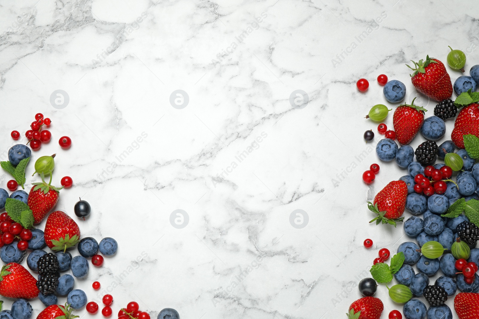 Photo of Mix of fresh berries on white marble table, flat lay. Space for text