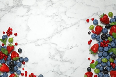 Mix of fresh berries on white marble table, flat lay. Space for text