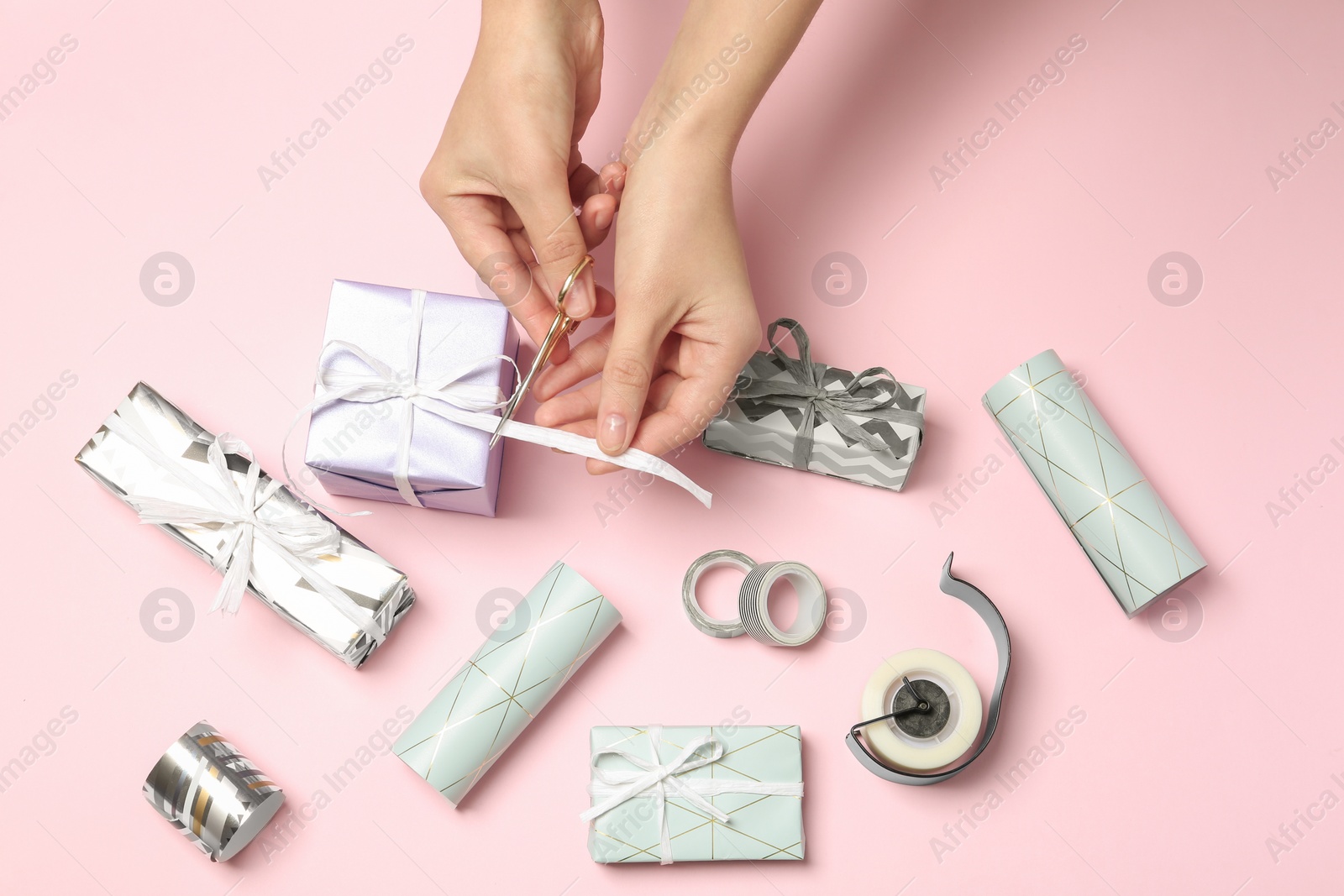 Photo of Woman decorating gift box on color background, top view