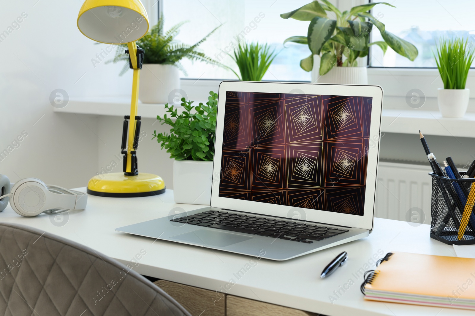 Photo of Cozy workspace with laptop on white wooden desk at home