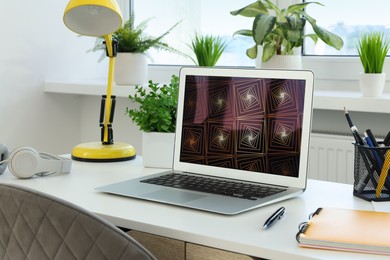 Cozy workspace with laptop on white wooden desk at home