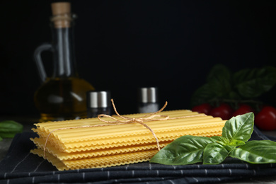 Uncooked lasagna sheets and basil on table