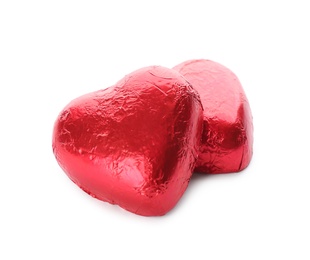 Photo of Heart shaped chocolate candies in red foil on white background