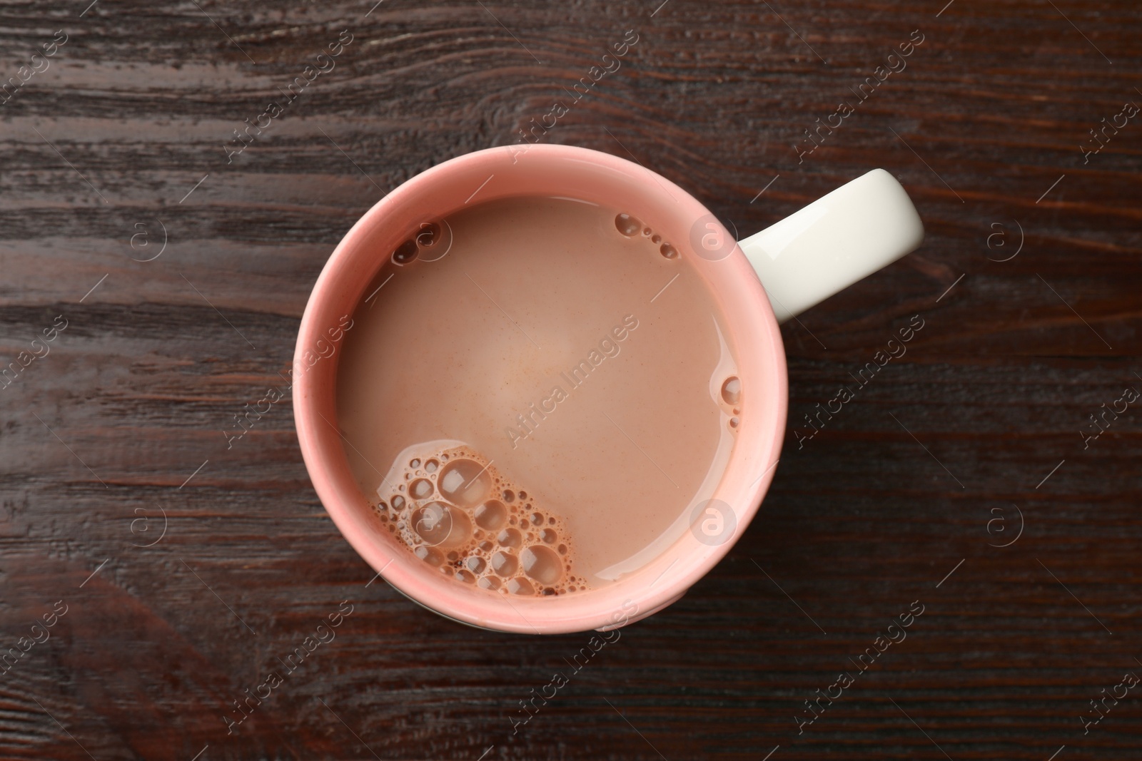 Photo of Tasty hot chocolate on wooden table, top view