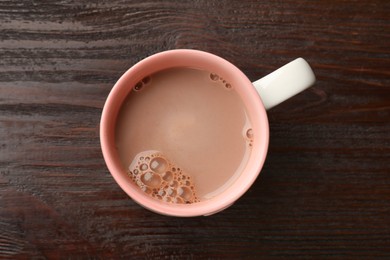 Tasty hot chocolate on wooden table, top view