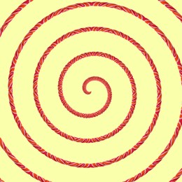 Image of Spiral of twisted candy stick on pale light yellow background