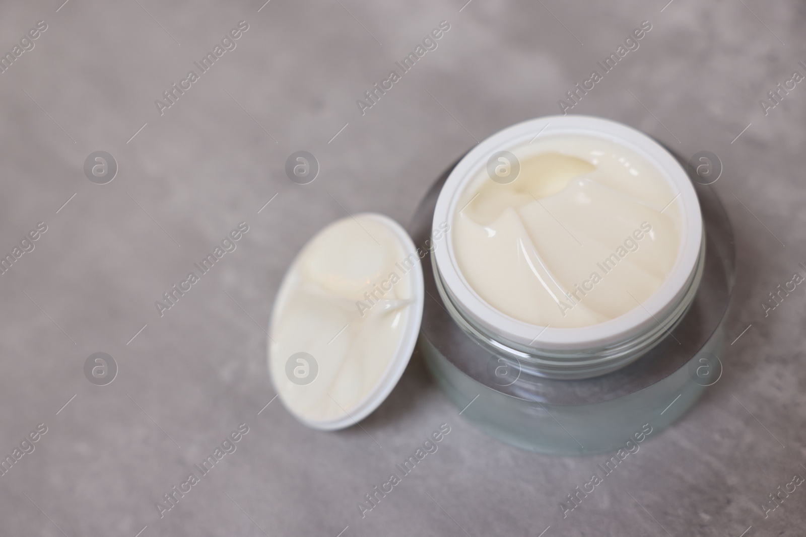 Photo of Body cream on grey table, closeup. Space for text