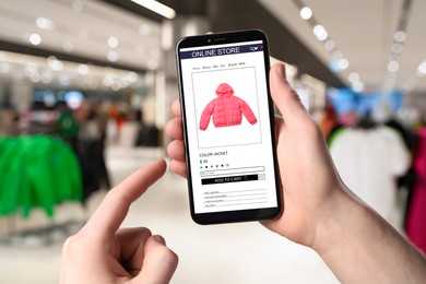 Image of Man visiting shop to take ordered jacket indoors, closeup. Online store website on device screen