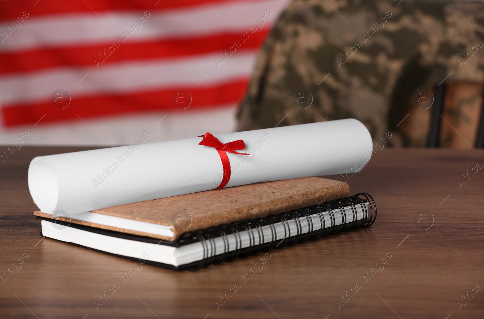 Photo of Diploma and notebooks on wooden table. Military education