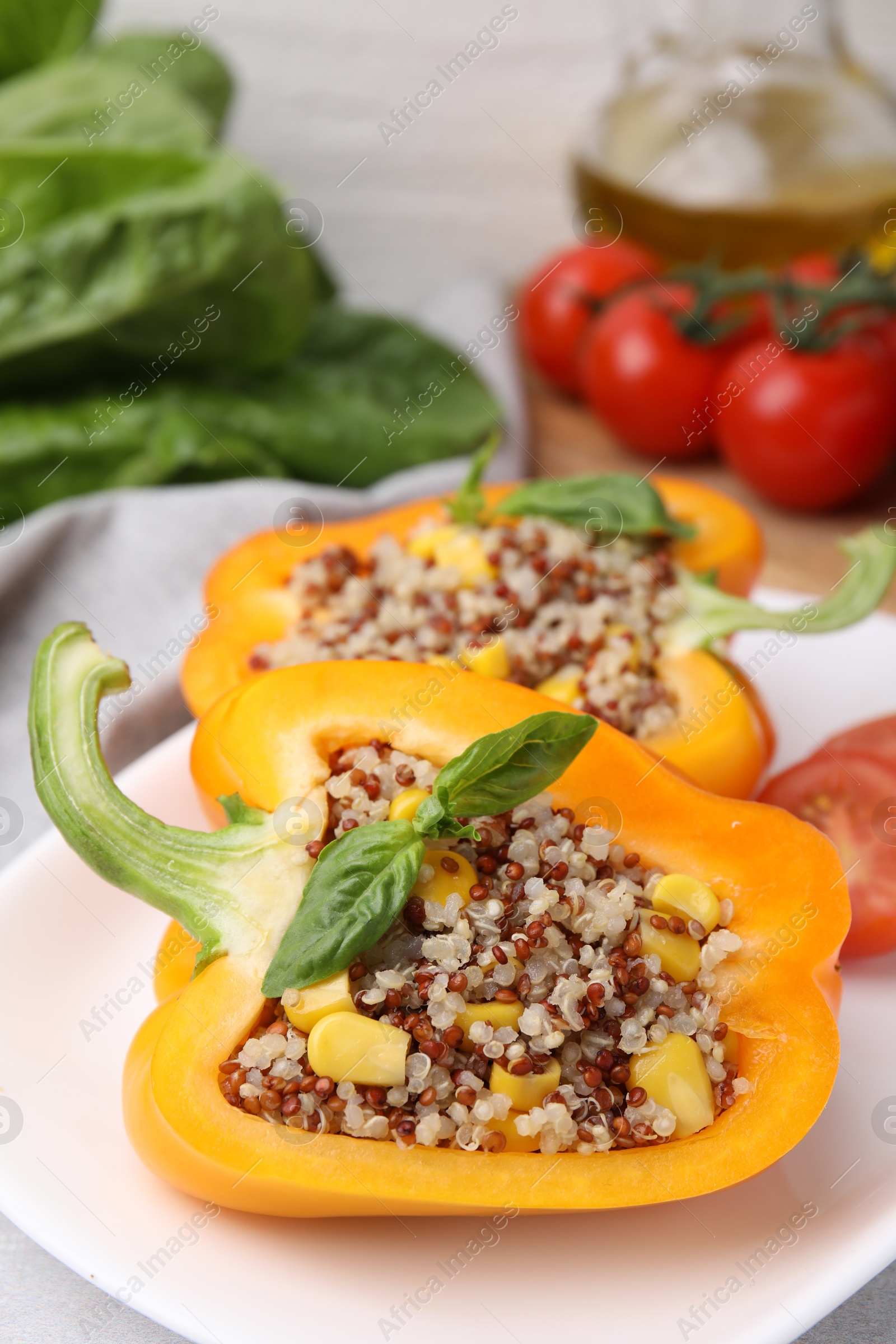 Photo of Quinoa stuffed bell pepper with basil on table, closeup