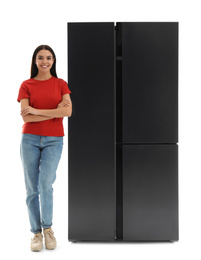 Photo of Young woman near refrigerator on white background