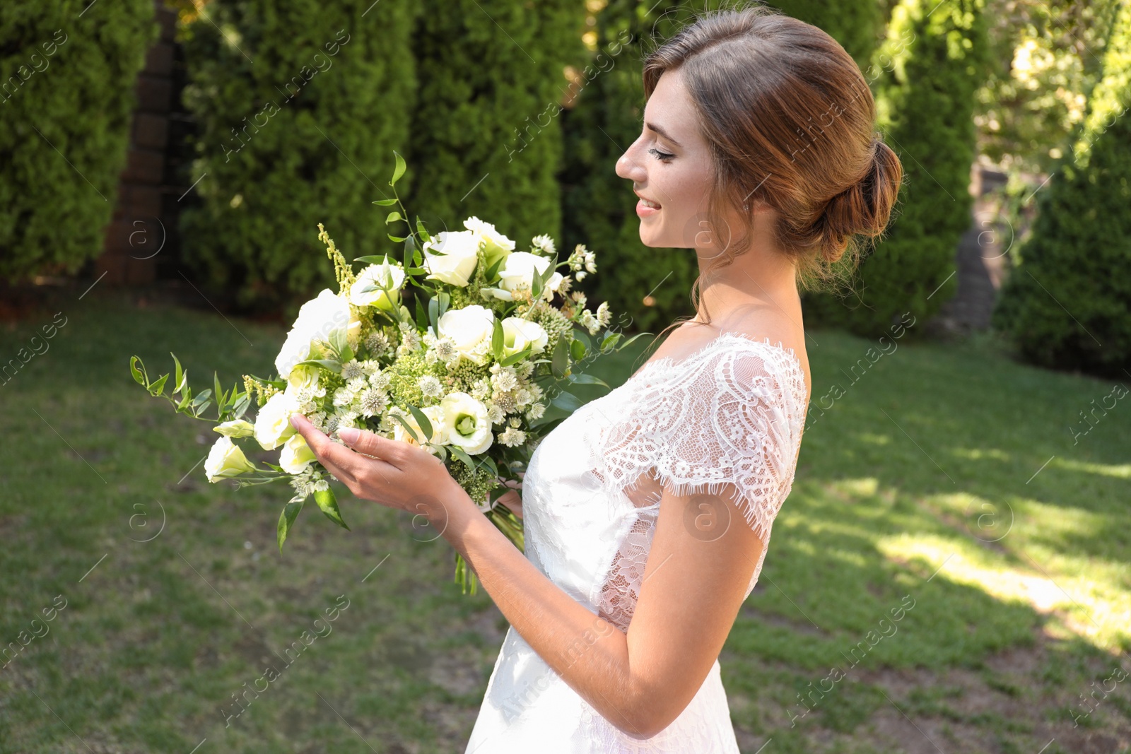 Photo of Gorgeous bride in beautiful wedding dress with bouquet outdoors