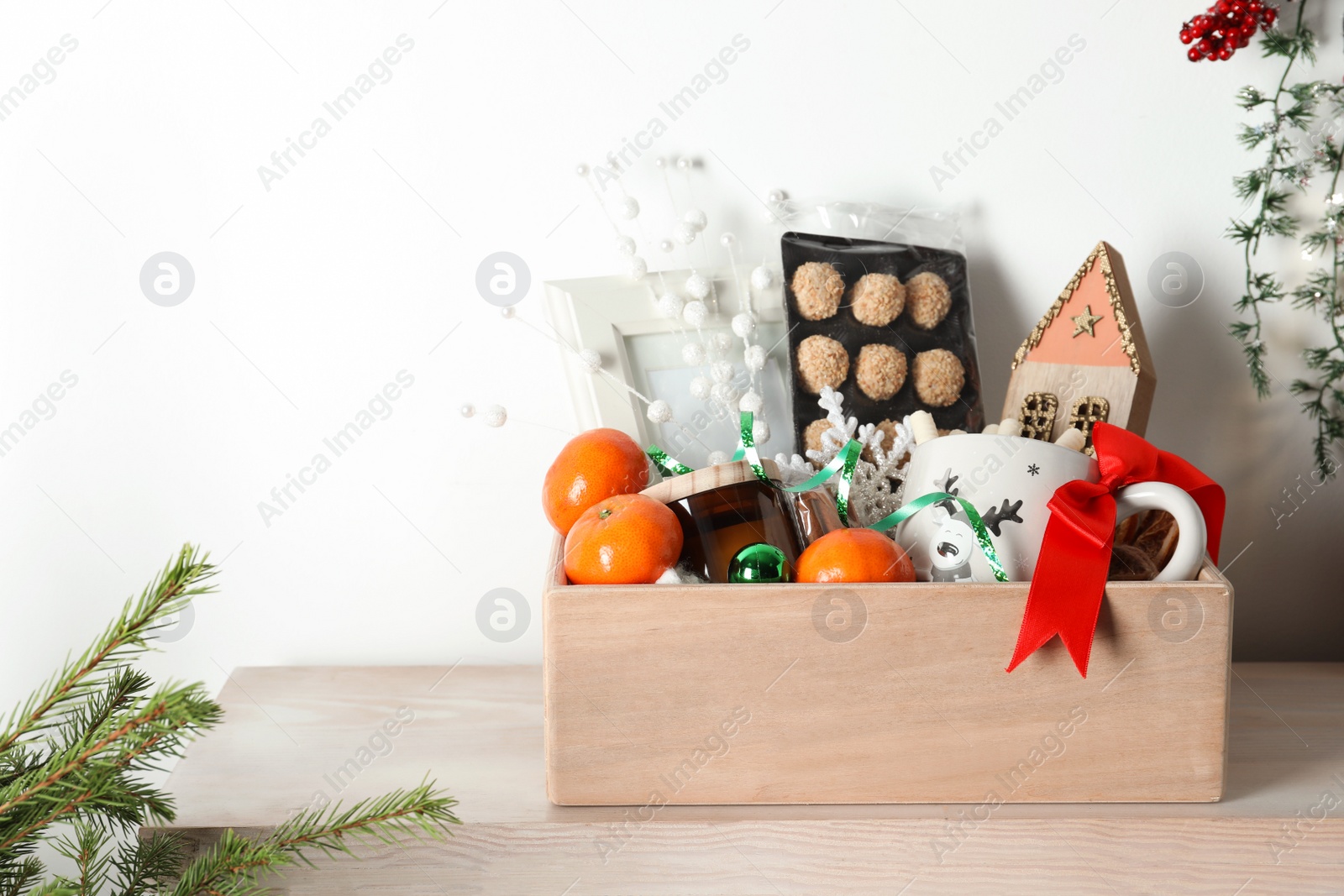 Photo of Crate with gift set and Christmas decor on wooden table