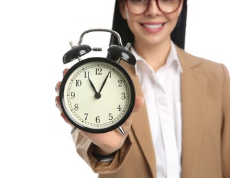 Photo of Businesswoman holding alarm clock on white background, closeup. Time management