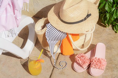 Photo of Stylish bag with different beach accessories near sunbed outdoors on sunny day