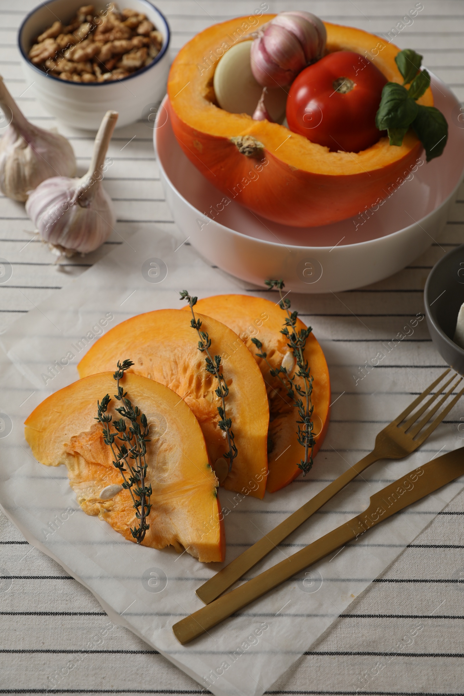 Photo of Fresh ripe pumpkin with aromatic thyme and vegetables on tablecloth