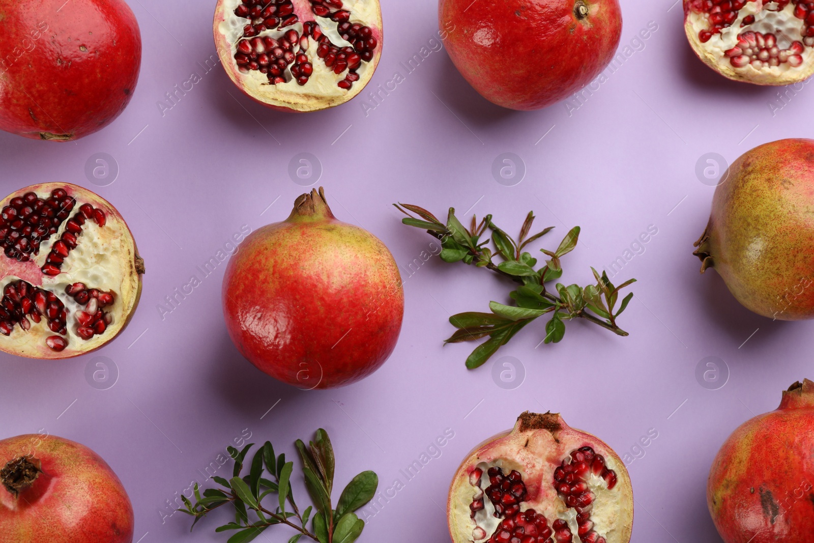 Photo of Flat lay composition with ripe pomegranates on violet background