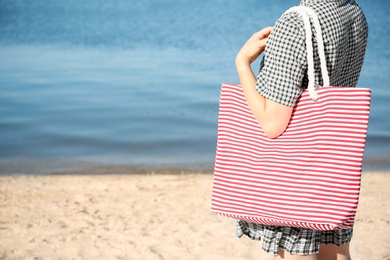 Woman with bag on beach. Space for text