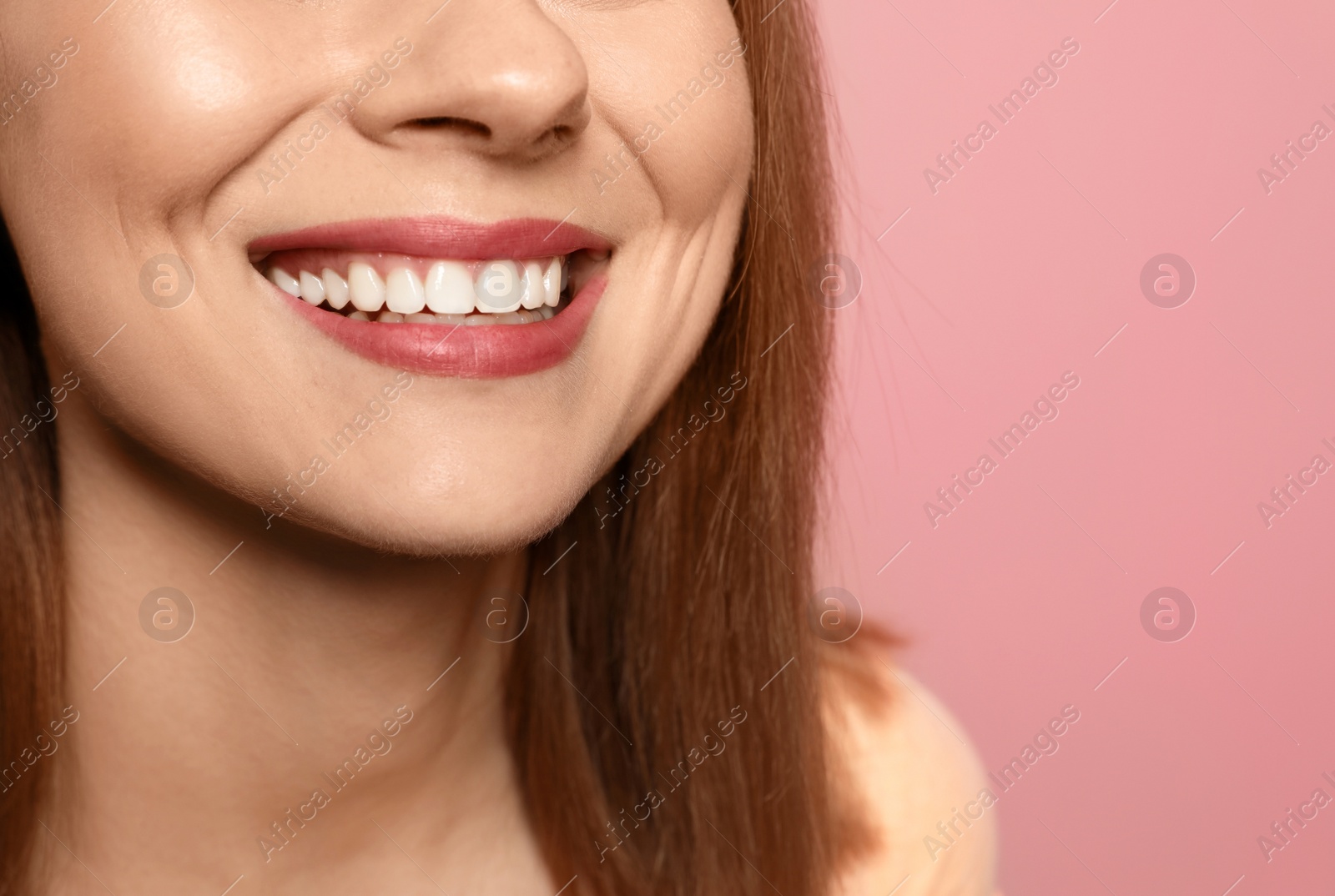 Photo of Smiling woman with perfect teeth on color background, closeup. Space for text