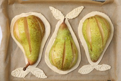 Photo of Tray with raw dough and fresh pears, flat lay
