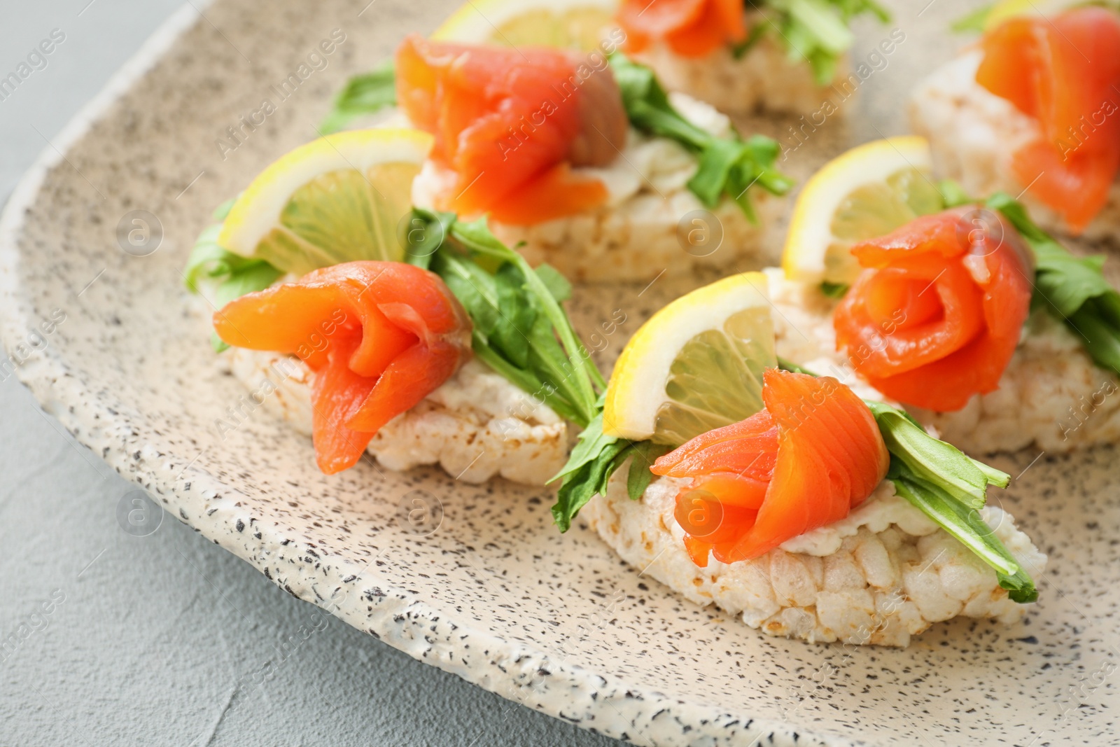 Photo of Crispbreads with fresh sliced salmon fillet on plate, closeup