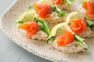 Photo of Crispbreads with fresh sliced salmon fillet on plate, closeup