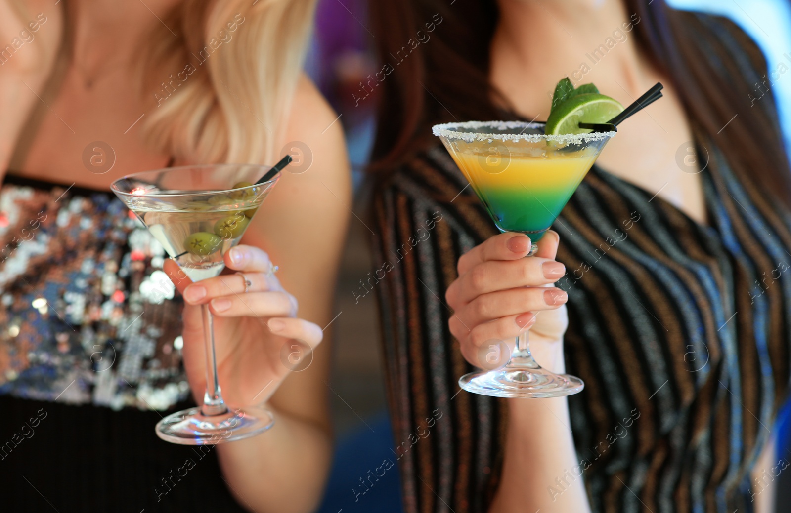 Photo of Young women with martini cocktails in bar, closeup