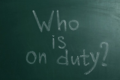 Photo of Phrase Who Is On Duty written on green chalkboard