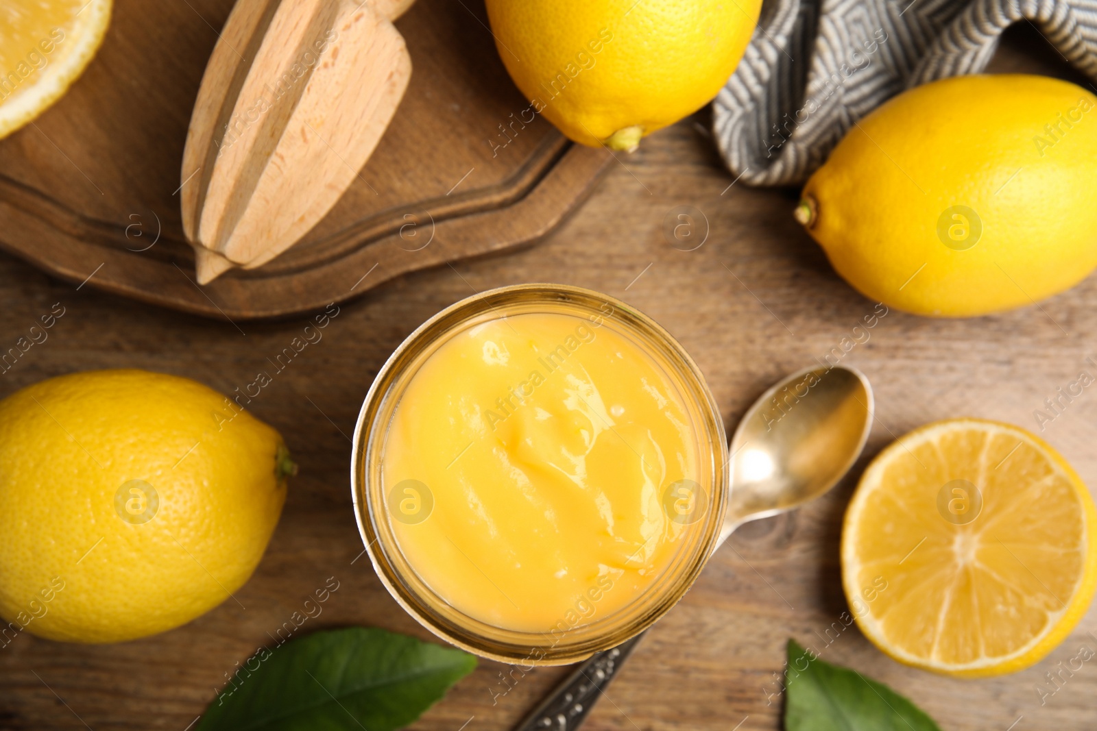 Photo of Delicious lemon curd and fresh fruits on wooden table, flat lay