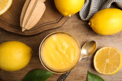 Delicious lemon curd and fresh fruits on wooden table, flat lay