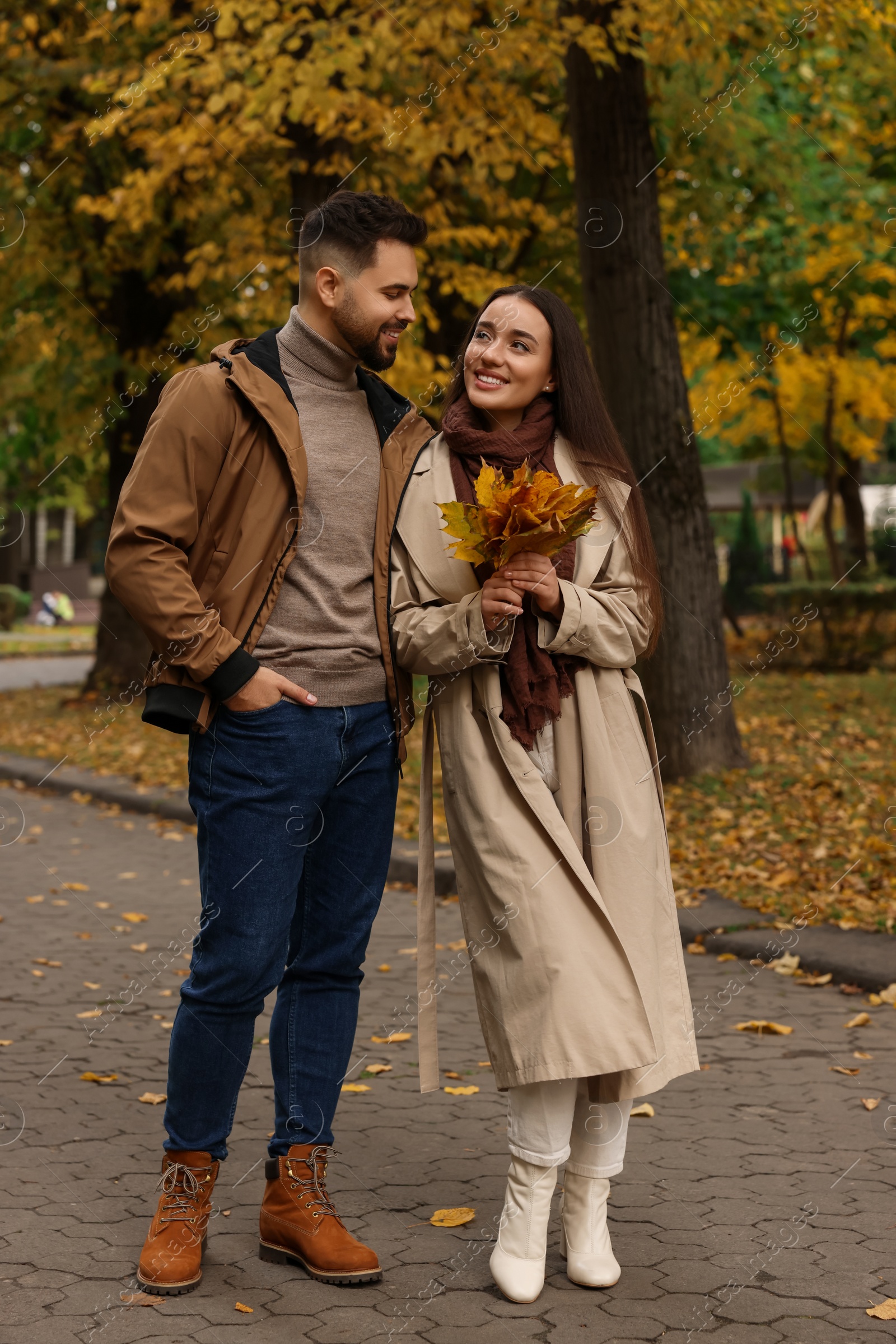 Photo of Happy young couple spending time together in autumn park