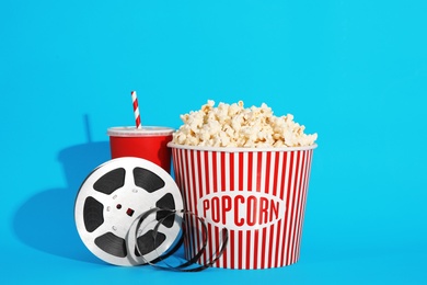 Photo of Popcorn, reel and drink on color background. Cinema snack