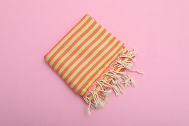 Photo of Folded striped beach towel on pink background, top view