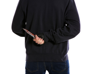 Photo of Man with bloody knife behind his back on white background, closeup. Dangerous criminal