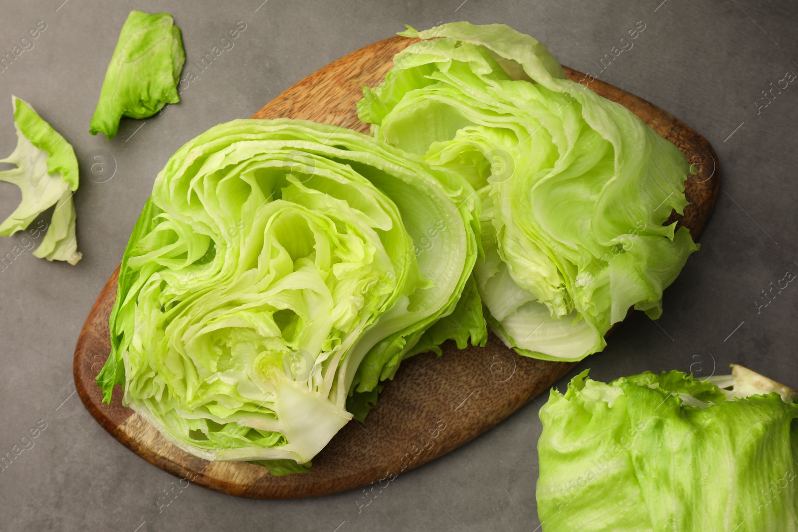 Photo of Flat lay composition with fresh green cut and whole iceberg lettuce heads on grey table