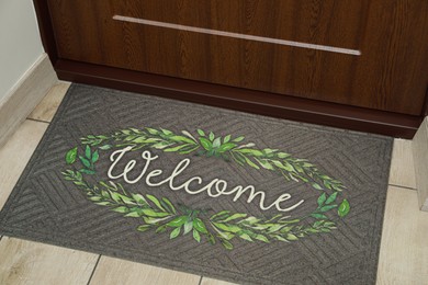 Photo of Beautiful doormat with word Welcome on floor near entrance