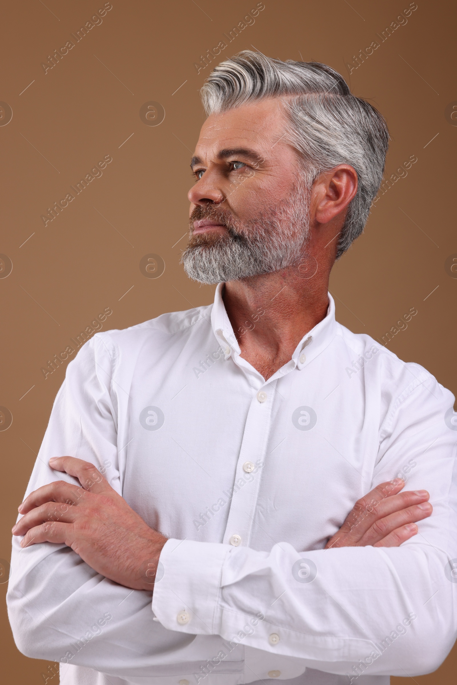 Photo of Portrait of confident man with beautiful hairstyle on light brown background