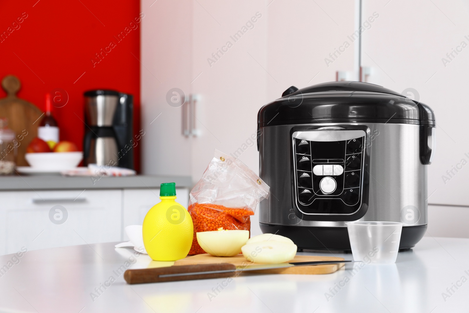 Photo of New modern multi cooker and products on table in kitchen. Space for text