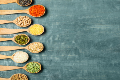 Photo of Flat lay composition with different types of legumes and cereals on blue wooden table, space for text. Organic grains