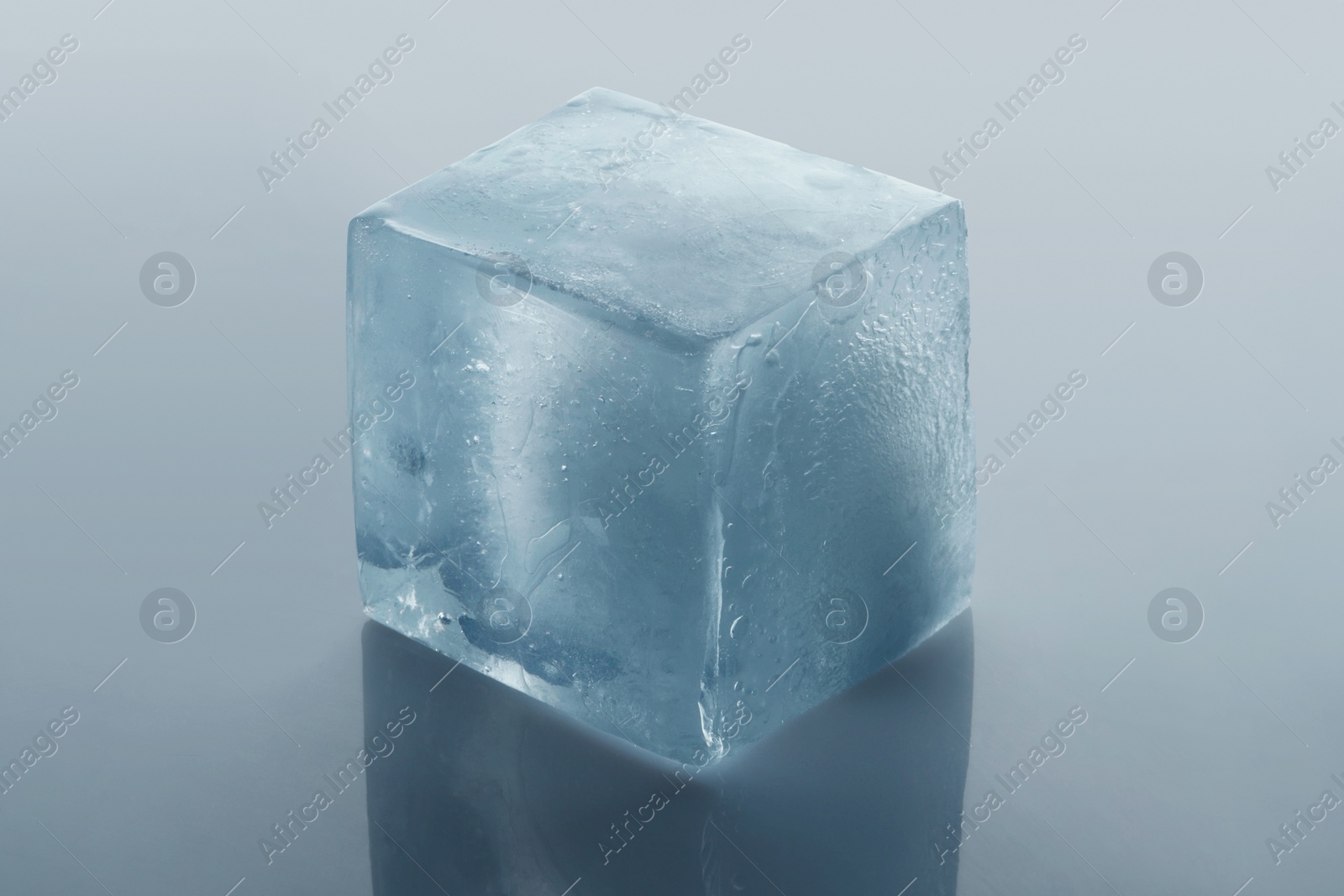 Photo of Crystal clear ice cube on light grey background