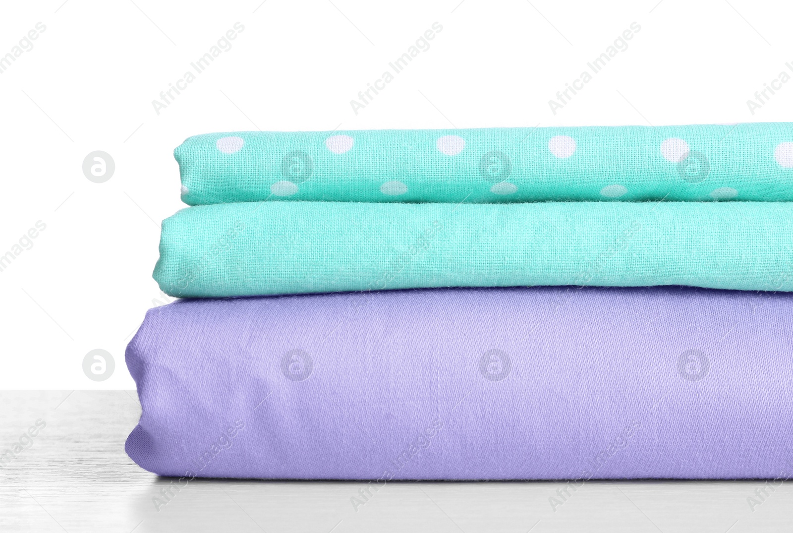 Photo of Stack of clean bed linen isolated on white