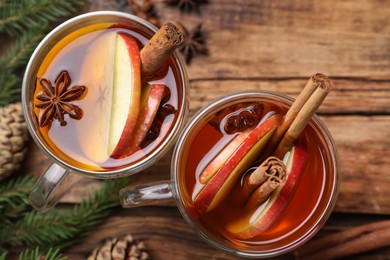 Photo of Hot mulled cider and fir branches on table, flat lay