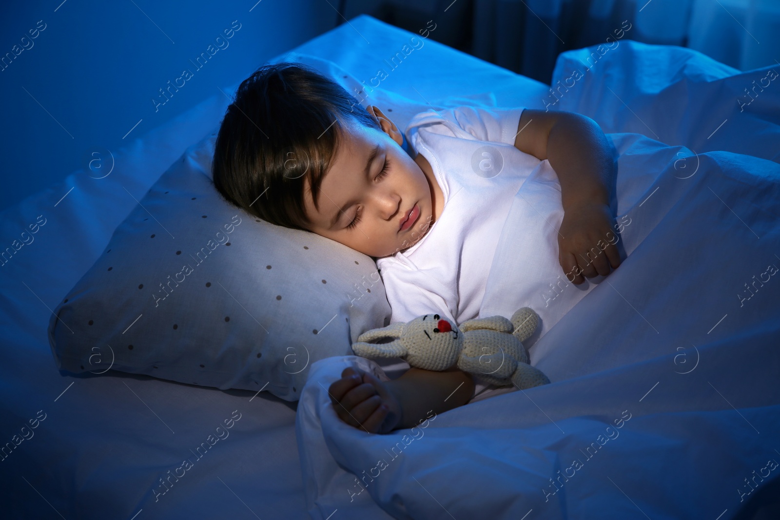 Photo of Cute little baby sleeping with toy at home. Bedtime