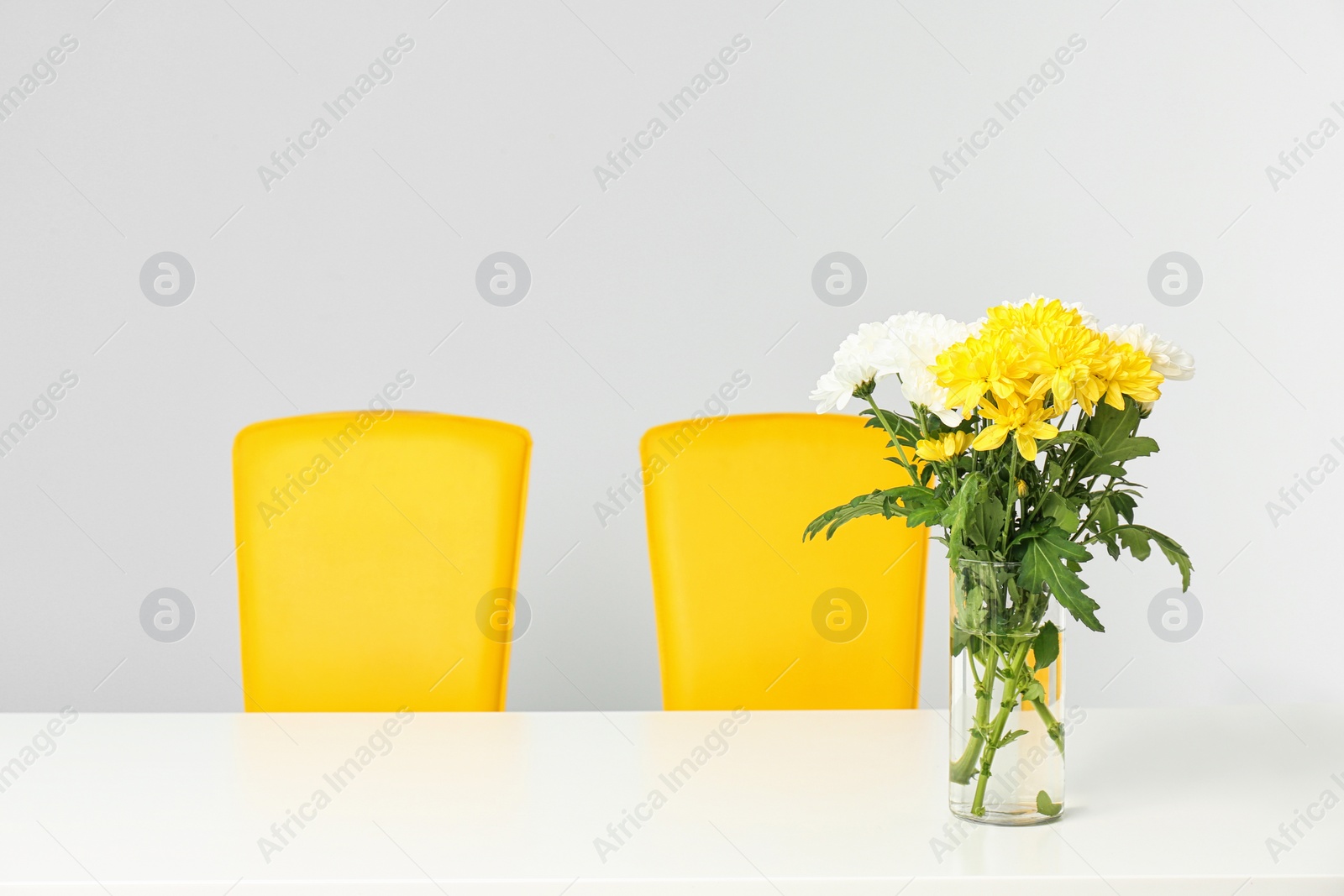 Photo of Vase with blooming flowers on table indoors