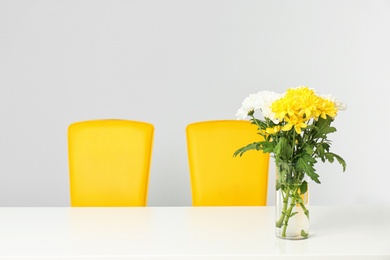 Photo of Vase with blooming flowers on table indoors