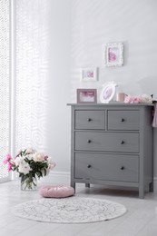 Grey chest of drawers in stylish room interior