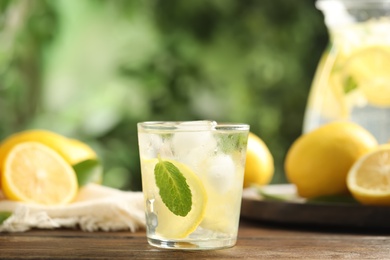 Cool freshly made lemonade and fruits on wooden table